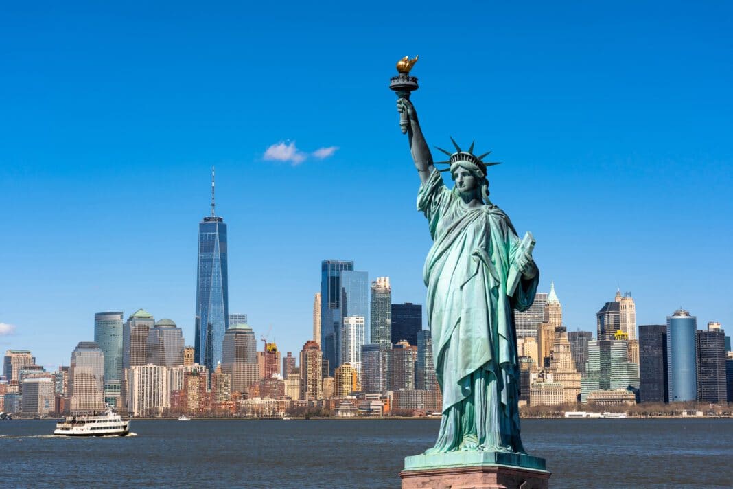 Die Freiheitsstatue vor der Silhouette von New York, Foto: ©THANANIT - stock.adobe.com