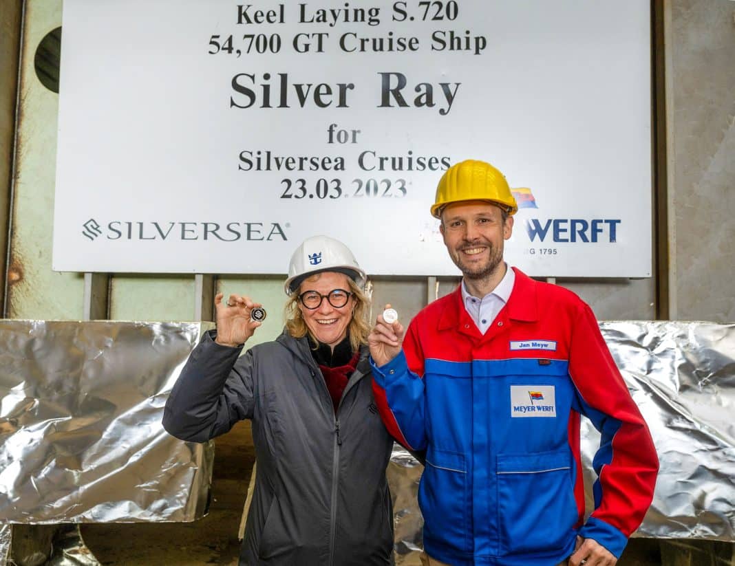 Barbara Muckermann, Präsidentin und CEO von Silversea, und Jan Meyer, Geschäftsführer der Meyer Werft, zeigen die Gedenkmünzen mit der Silhouette der Silver Ray. Foto: © Silversea Cruises