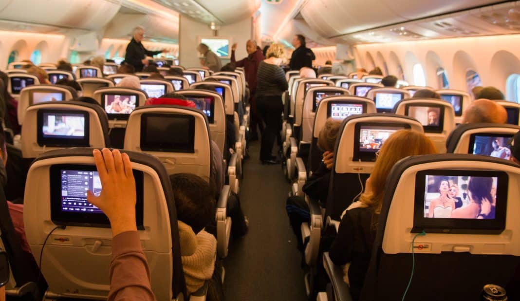 Passagiere im Flugzeug sehen sich Inflight Entertainment an. Foto: © Adobe Stock / Shawn Hamilton CLiX