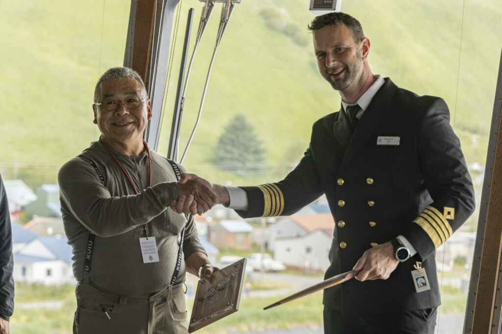 Jeffrey Peterson vom Alutiiq Tribe of Old Harbor überreicht Kapitän Bram Olof von der MS Roald Amundsen beim ersten Besuch von HX in Old Harbor ein zeremonielles Paddel. Foto: © HX Expeditions